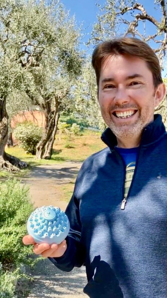 Franck fondateur d'aecodune avec la boule lessive dans un champ d'oliviers a Nice